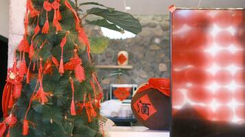 A room with a Christmas tree decorated with red ornaments and a red lantern.
