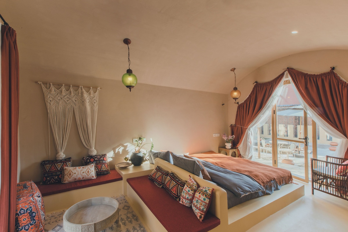 Una habitación acogedora con una cama, una mesita y una ventana con cortinas.