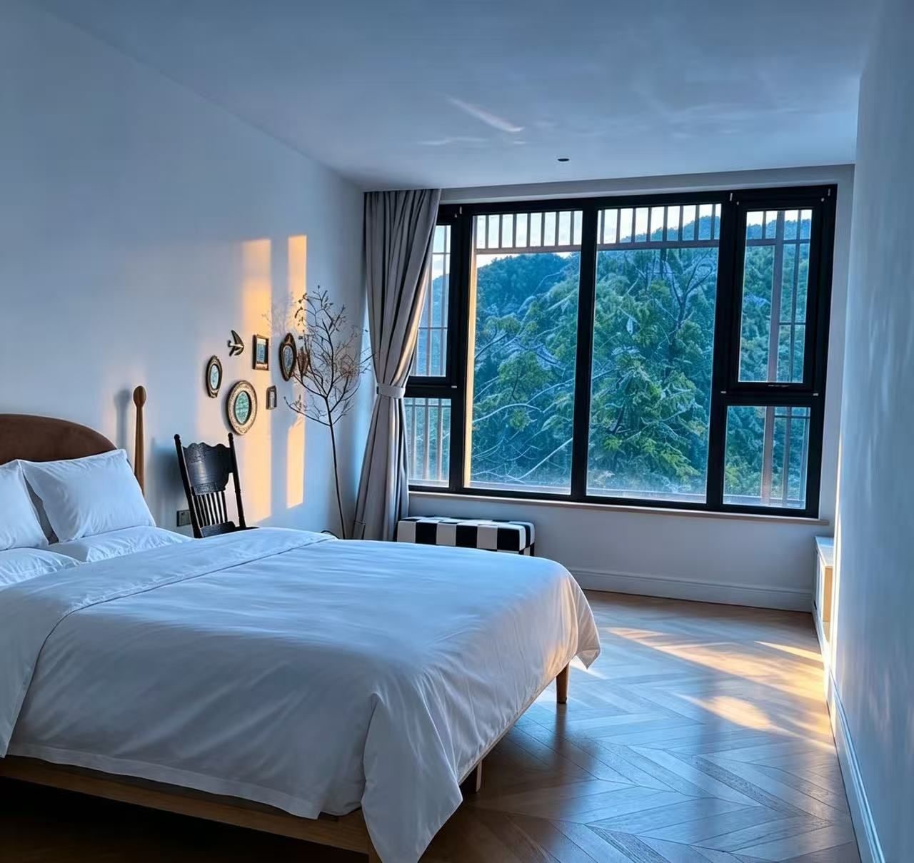 Un dormitorio con un ventanal grande, una cama, una silla y un radiador.