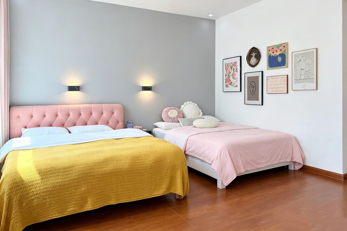 Un dormitorio con dos camas, un cabecero rosa y luces fijadas a la pared.