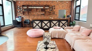 A hotel room with a brick wall, a bed, a desk, and a window. - Qiran Rustic Resort Villa (Huairou)