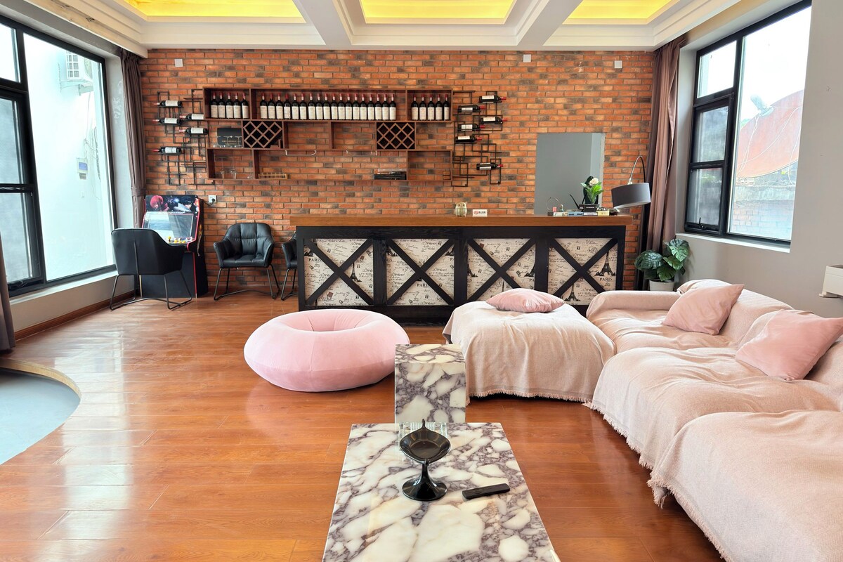Una habitación de hotel con pared de ladrillo, cama, escritorio y ventana.