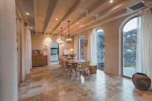 Un comedor espacioso con techo alto, ventanas grandes y vistas al exterior.
