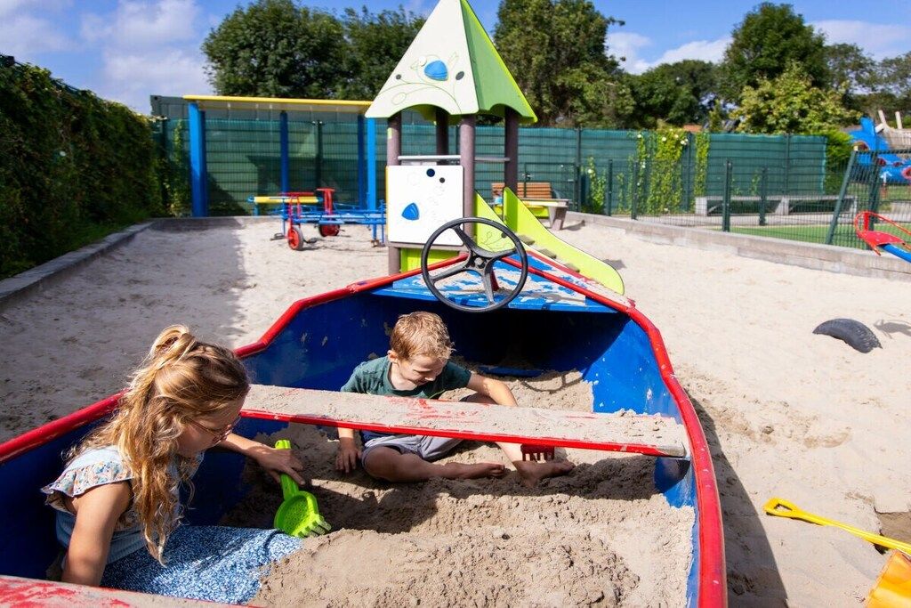 Ein Spielbereich für Kinder mit Sandkasten und Rutsche.