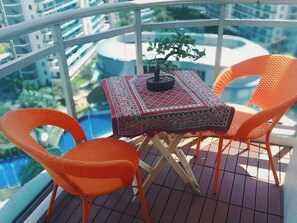 A balcony with a table, chairs, and a potted plant. - 2BR Tropical Scandi Suite (Parañaque)