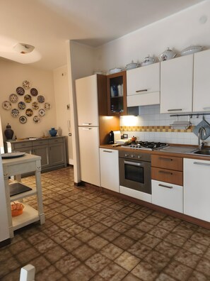 A modern kitchen with white cabinets, a gas stove, and a tiled backsplash.