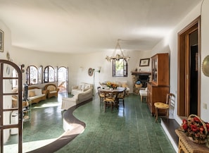 A spacious living area with a curved floor, a dining table with chairs, and a fireplace.