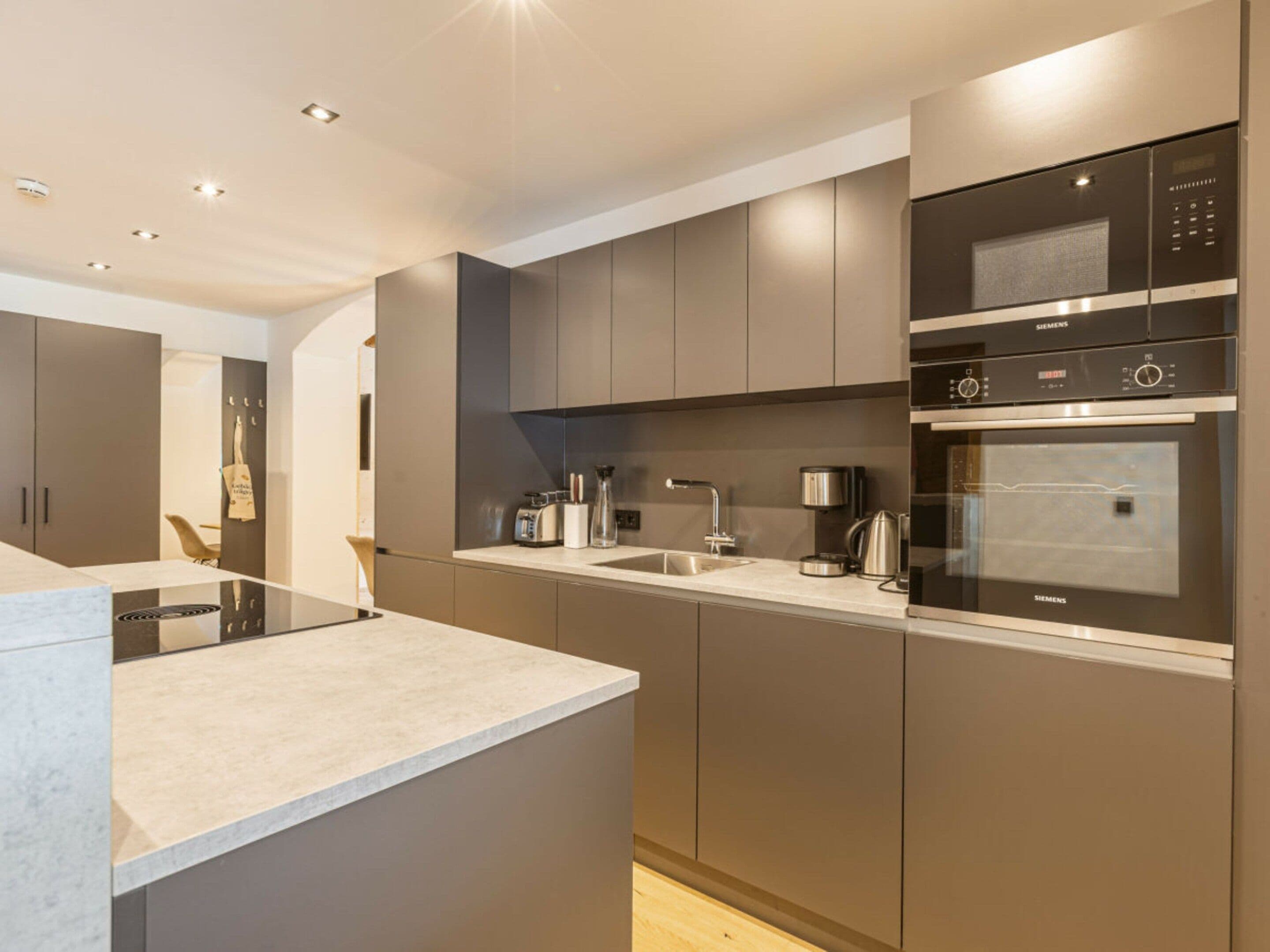 A modern kitchen with built-in appliances, a countertop, and cabinets.