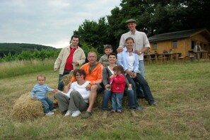 A group of people gathered outdoors with a wooden cabin in the background. - 4 Weingut Hauerhof 99 (Klosterneuburg)