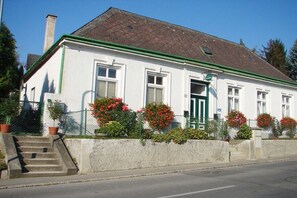 A two-story building with a green door, white walls, and a red roof. - 4 Weingut Hauerhof 99 (Klosterneuburg)
