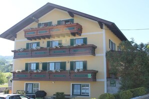 Ein mehrstöckiges Hotel mit Balkonen, ein Auto vor der Tür und ein Schild, das ein Restaurant anzeigt.
