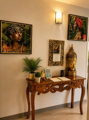 Ein Holzkonsolentisch mit Spiegel, Buddha-Statue und Dekorationselementen.