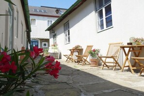 A courtyard with stone flooring, wooden furniture, and potted plants. - 2 Weingut Hauerhof 99 (Klosterneuburg)