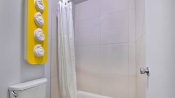 Un baño con inodoro, bañera y cortina de ducha.