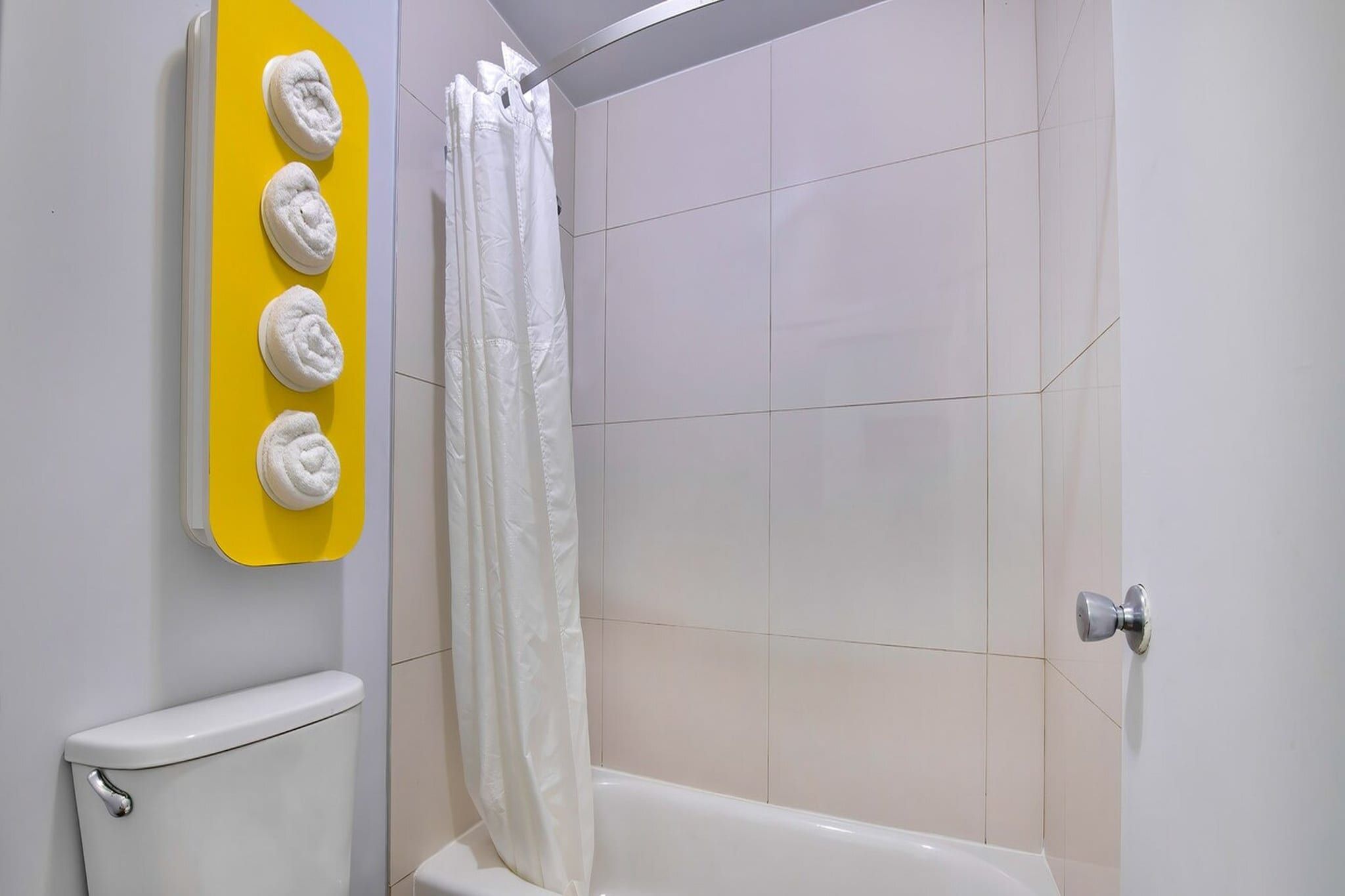 Een badkamer met toilet, bad en douchegordijn.