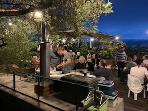 An outdoor dining area with tables and chairs, surrounded by trees and a view of the mountains. - studio21 seven (Pretoria)
