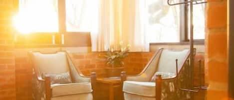 A room with a large window, two chairs, a small table, and a rug.
