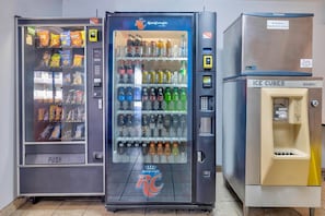 Three beverage vending machines with various drink options.