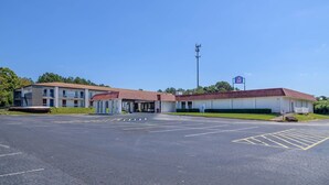 Motel amb un pàrquing i un cel blau clar.