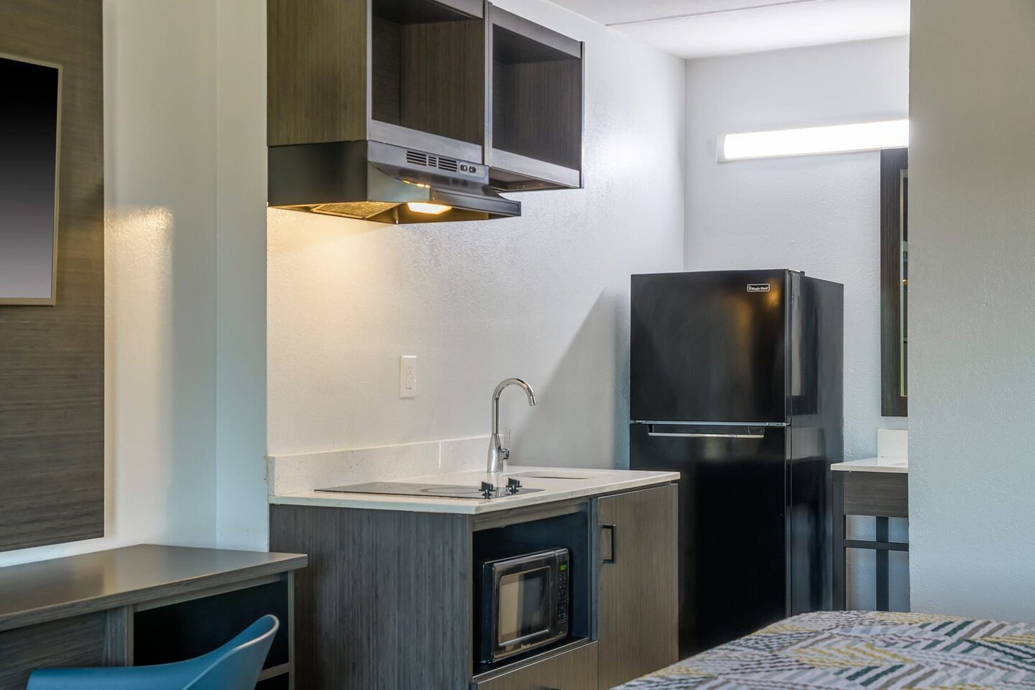 Una kitchenette compacta con horno integrado, pileta y refrigerador.