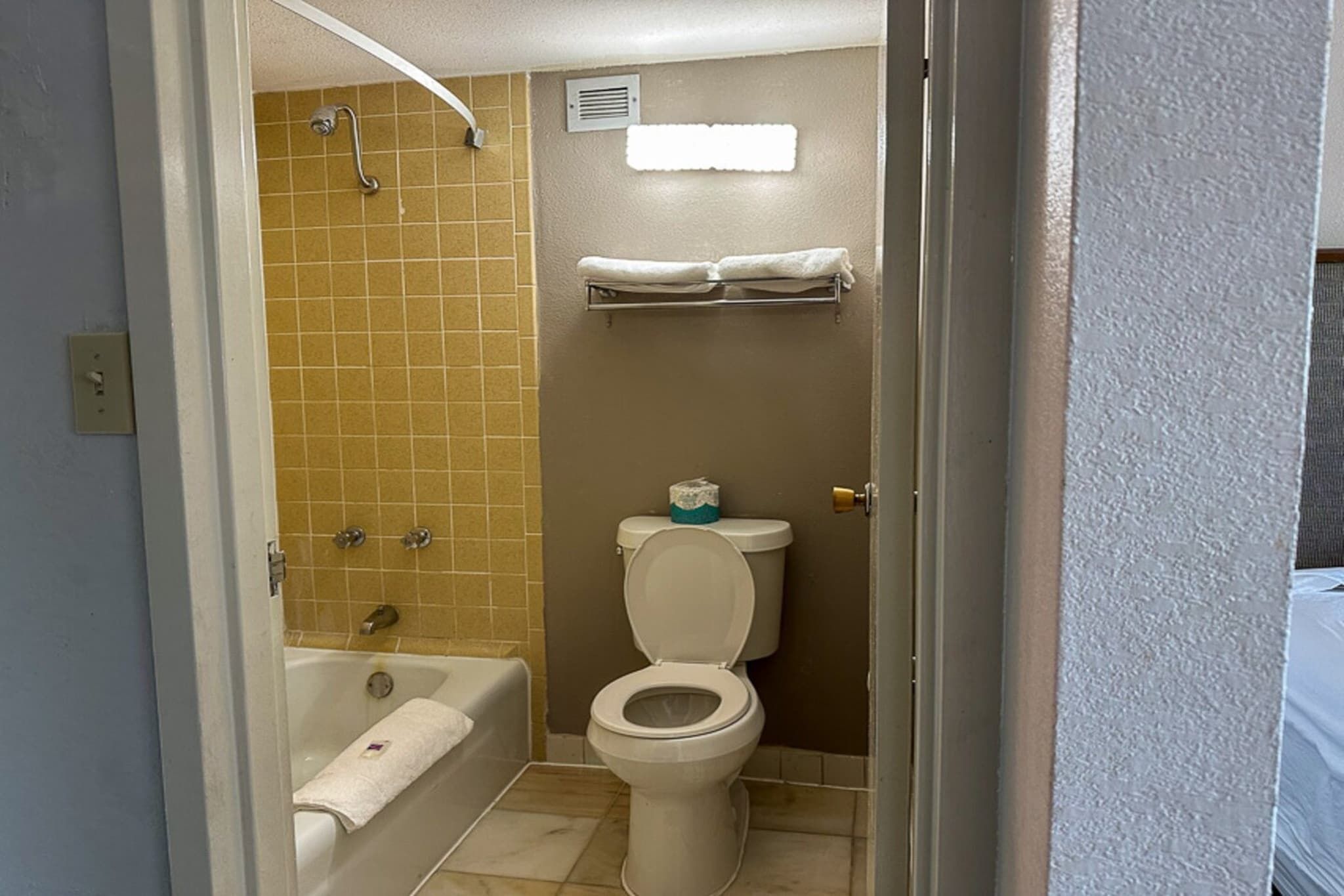 A bathroom with a bathtub, toilet, and a shower area.