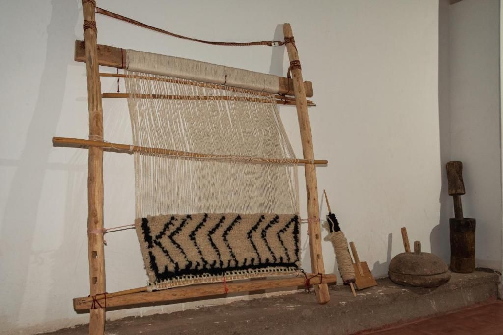 Un métier à tisser traditionnel sur lequel on peut voir un textile en cours de réalisation.