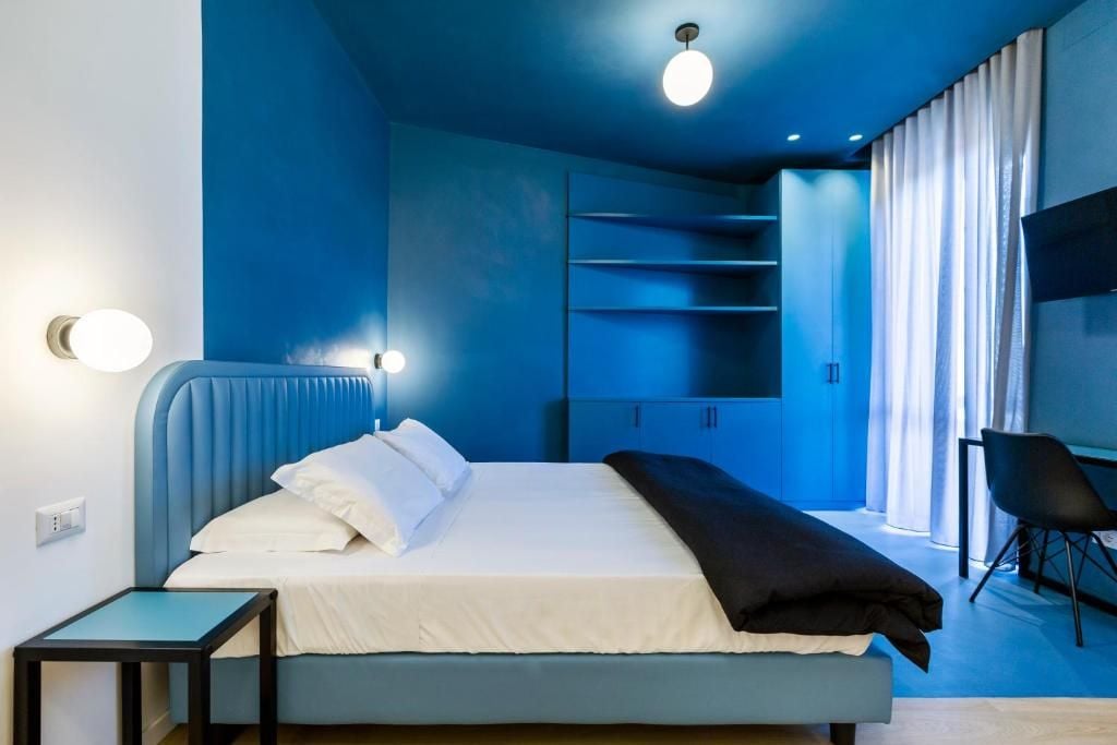 A bedroom with a bed, bedside tables, a chair, and built-in shelving.