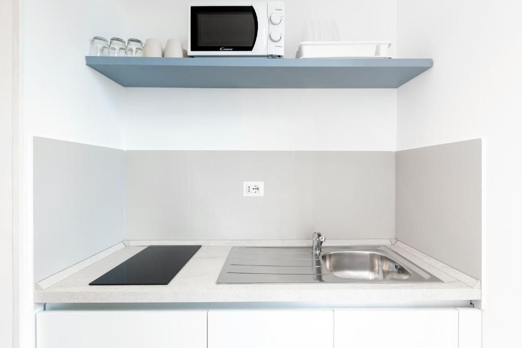 A kitchen with a microwave, a sink, and a countertop.