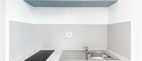 A kitchen with a microwave, a sink, and a countertop.