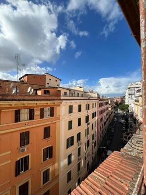 Vista de un paisaje urbano con edificios altos, cielo despejado y una calle abajo.