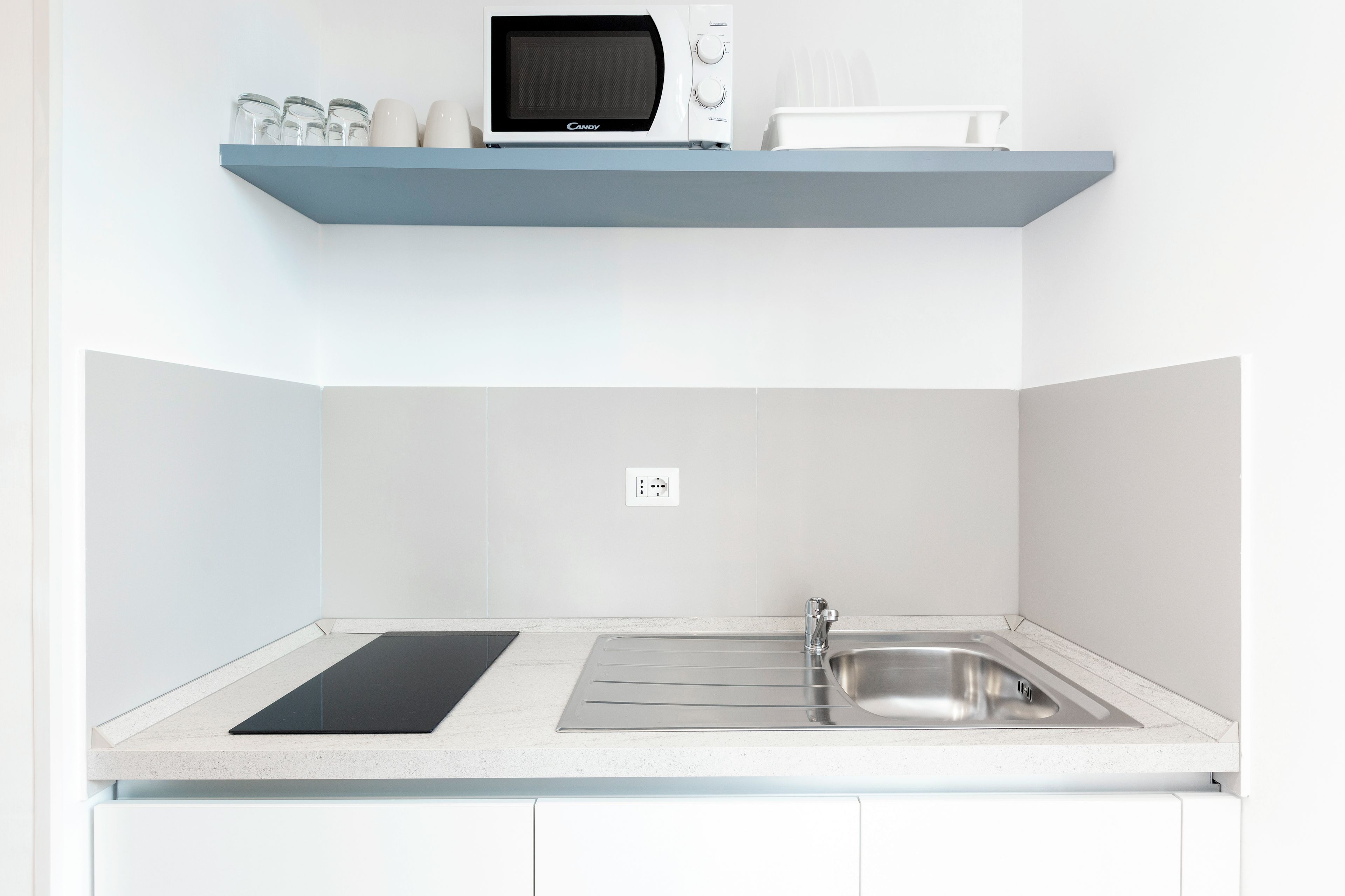A kitchen with a microwave, a sink, and a countertop.