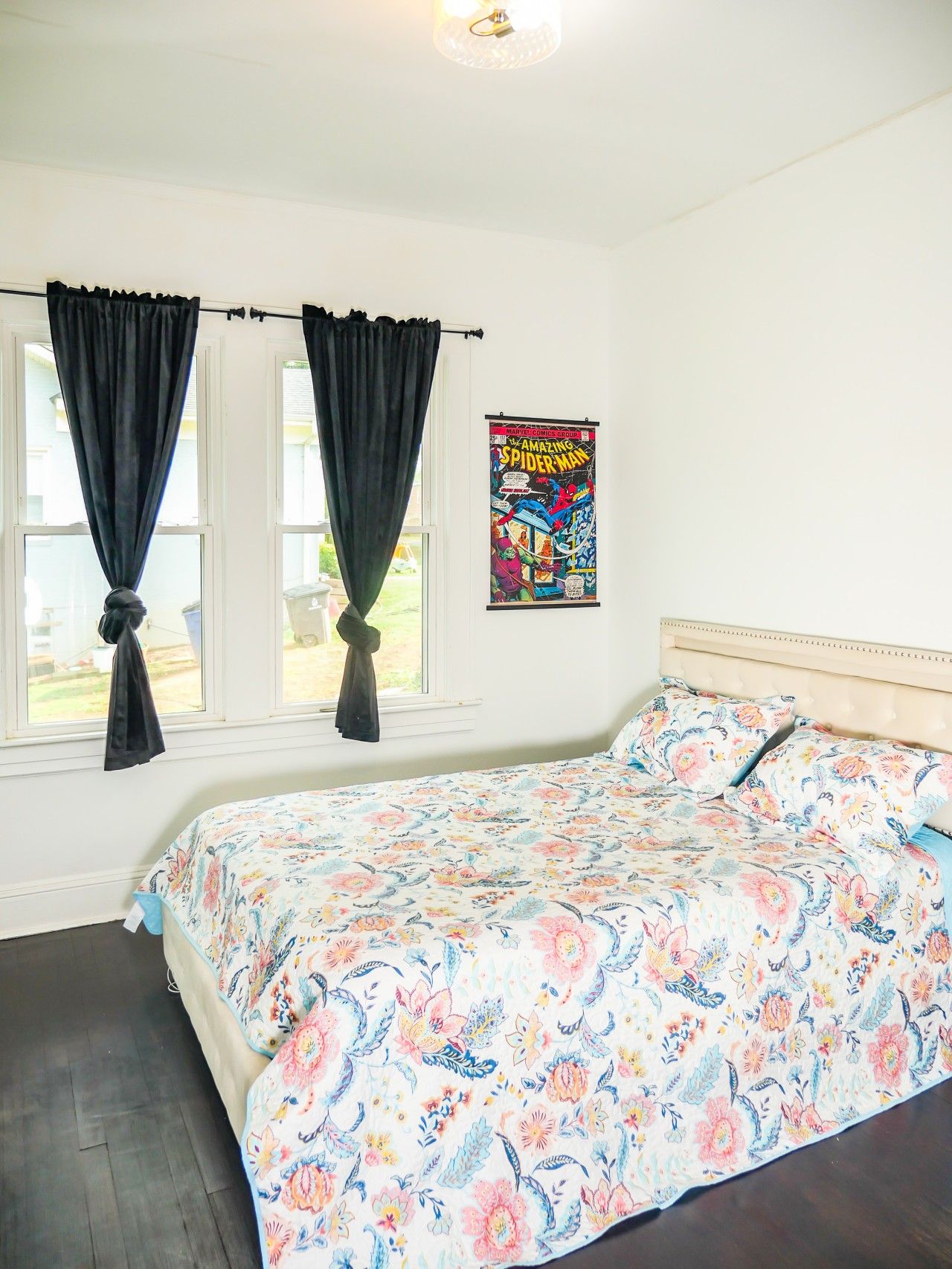 Un dormitorio con cama, cortinas, un cartel y una ventana.
