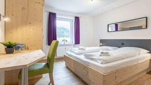 Une chambre à coucher avec un lit en bois, un bureau et une chaise.