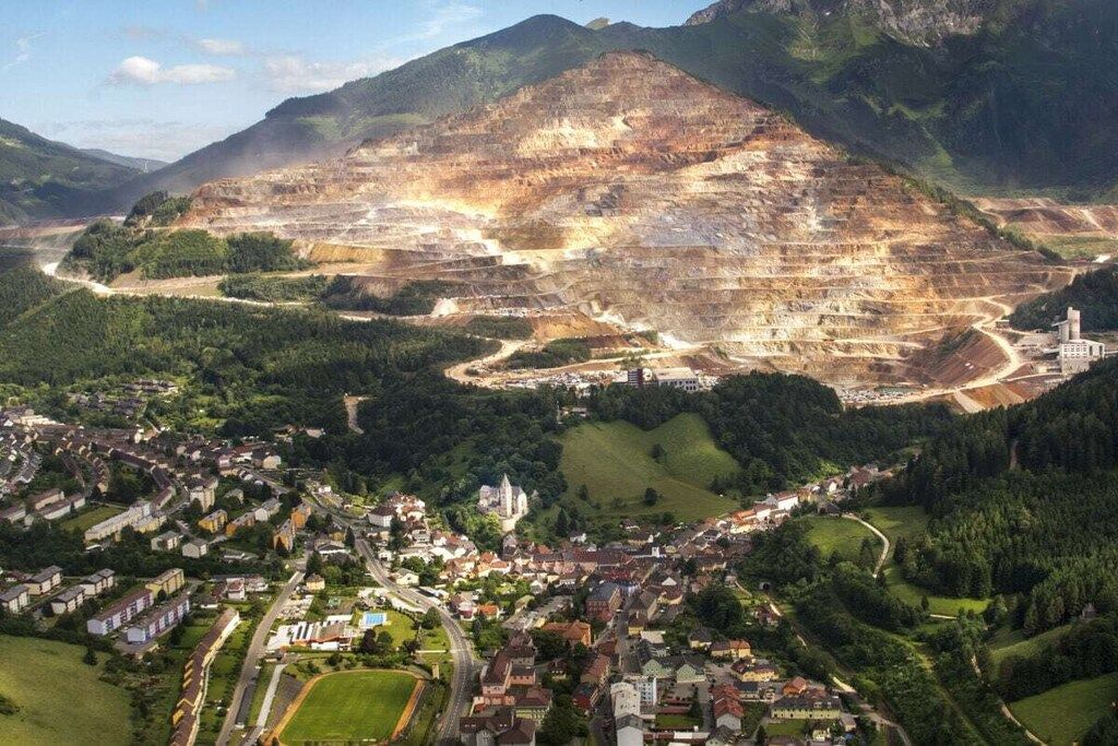 An aerial view of a town with a large open quarry and surrounding residential areas.