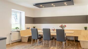 Une cuisine moderne avec un plan de travail en bois, quatre chaises et un banc intégré.