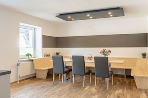 A modern kitchen with a wooden countertop, four chairs, and a built-in bench.