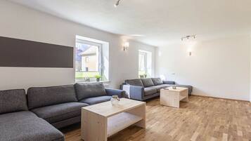 A modern living room with a sectional sofa, a coffee table, and a small side table.