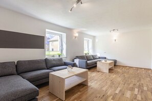 A modern living room with a sectional sofa, a coffee table, and a small side table.