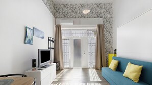 Uma sala de estar moderna com televisão, sofá e área de jantar.