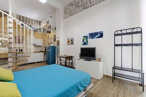 A compact hotel room with a bed, a desk with a computer, a TV, and a bunk bed. - Apartment 'Chicco & Mirca Loft in Rome Metro A' with Wi-Fi and Air Conditioning (Roma)