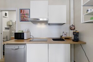 A compact kitchen with a microwave, toaster, coffee maker, and a dishwasher. - Apartment 'Chicco & Mirca Loft in Rome Metro A' with Wi-Fi and Air Conditioning (Roma)
