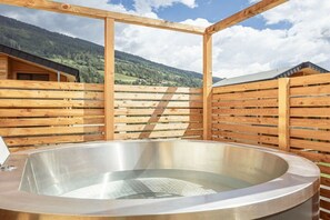 A hot tub in a wooden structure with a view of a mountainous landscape. - Apartment with 1 bedroom (St. Georgen am Kreischberg)
