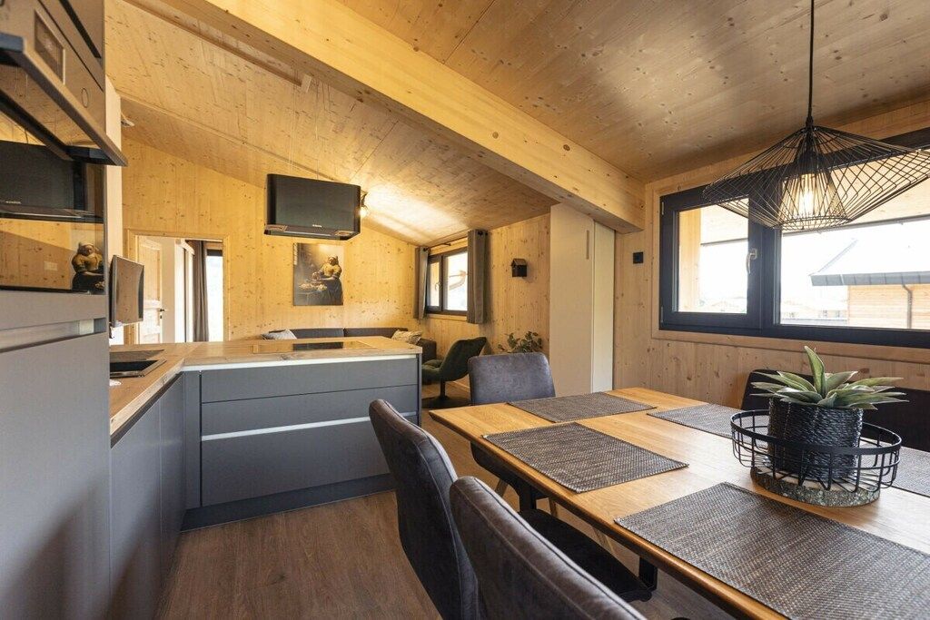 Eine moderne Küche mit Holzausstattung und einem Essbereich mit Holztisch und Stühlen.
