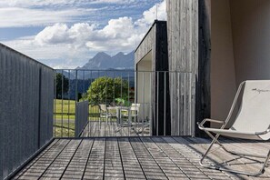 A balcony with a view of mountains, a metal railing, and a white chair. - Apartment in Rohrmoos-Untertal with balcony (Rohrmoos-Untertal)