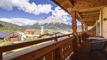 A wooden balcony with a view of a mountain and a church.