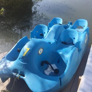 Een blauw vaartuig met het nummer '1' en de tekst 'Water B' erop, afgemeerd aan een houten steiger.