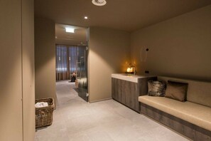 Eine Hotelhalle mit einer Rezeption, einer Sitzecke und Blick in einen Zimmer.