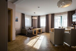 Uma sala de estar moderna com sofá, mesa pequena e televisão.