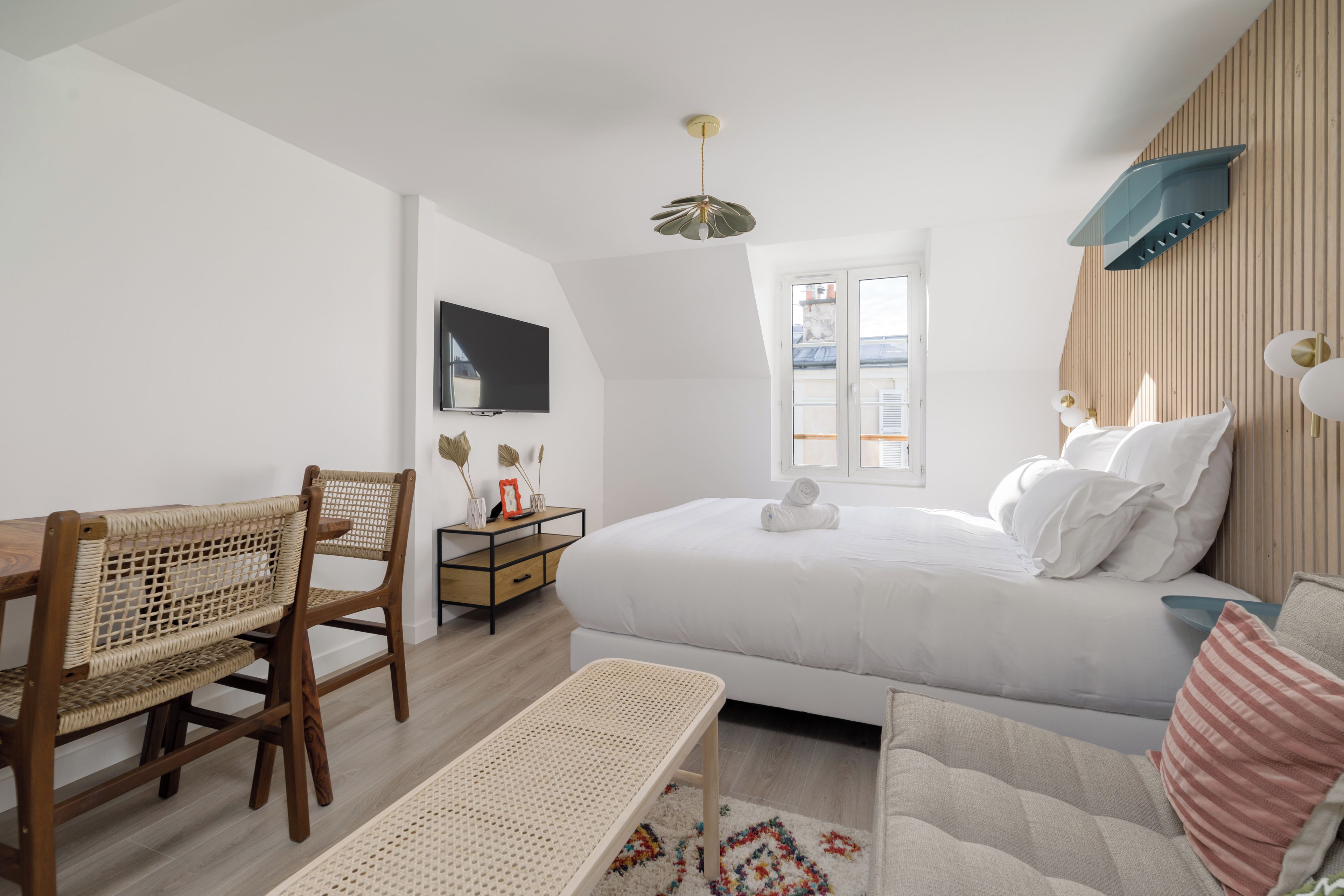 Een slaapkamer met een bed, een bureau, een stoel en een raam.