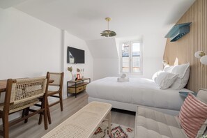 Ein Schlafzimmer mit Bett, Schreibtisch, Stuhl und Fenster.